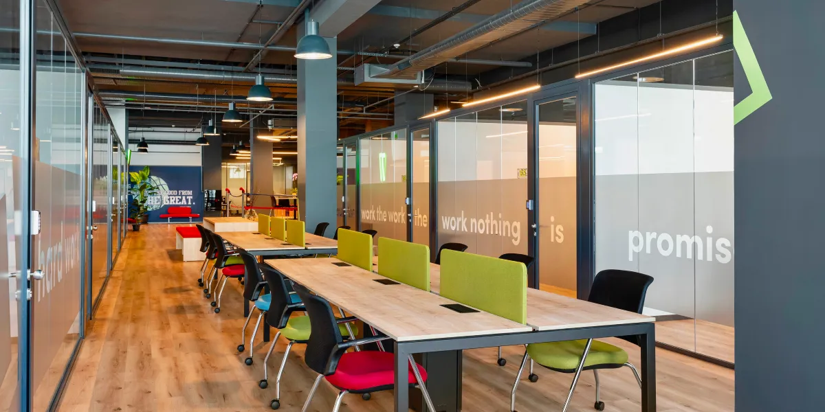 Bizworld's Atakent coworking space featuring modern coworking desks, vibrant chairs, private offices, and a unique boxing ring in the background, blending work and wellness.